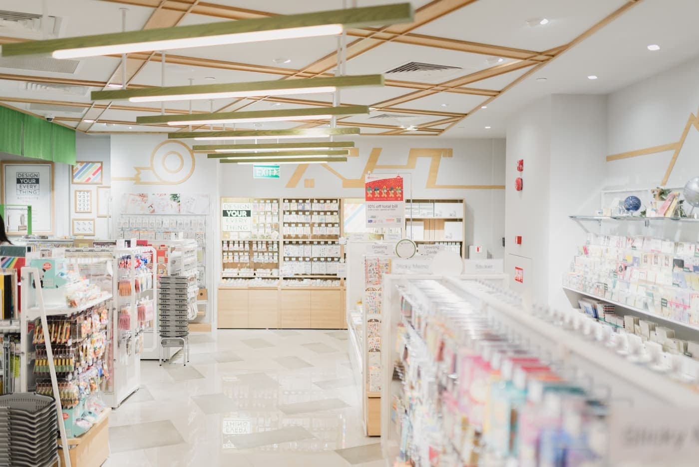 Allée centrale d’un magasin moderne aux étagères blanches, sol carrelé et plafond à lamelles bois